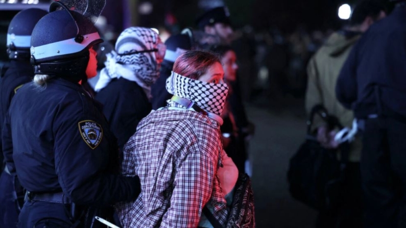 Agentes de la policía de Nueva York detienen a estudiantes manifestantes mientras desalojan un edificio de la Universidad de Columbia, en Nueva York, el 30 de abril de 2024, que había sido atrincherado por manifestantes pro-Palestina. (Charly Triballeau/AFP vía Getty Images)
