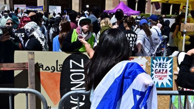 Manifestantes pro-Israel y pro-Palestina se enfrentan separados por barreras metálicas en la UCLA el 26 de abril de 2024. (Frederic J. Brown/AFP vía Getty Images)