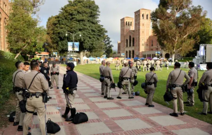Agentes de la Patrulla de Carreteras de California (CHP) vigilan un campamento pro-Palestina la mañana después de que fuera atacado por manifestantes contrarios en el campus de la Universidad de California en Los Ángeles (UCLA) en Los Ángeles, California, el 1 de mayo de 2024. (Mario Tama/Getty Images)