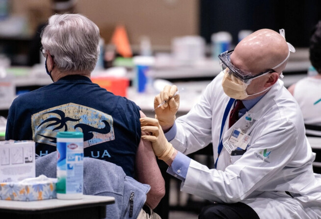 Un hombre recibe una dosis de la vacuna COVID-19 de Pfizer en el Amazon Meeting Center, en el centro de Seattle, el 24 de enero de 2021. (Grant Hindsley/AFP vía Getty Images)
