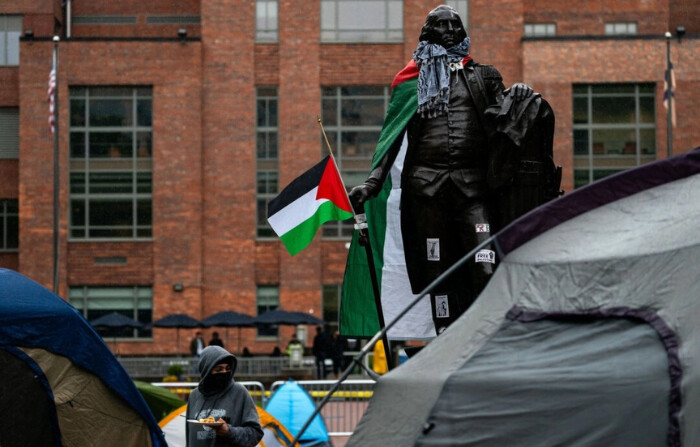Se ve una estatua de George Washington con una bandera de Palestina y un keffiyeh mientras activistas y estudiantes protestan cerca de un campamento en University Yard de la Universidad George Washington, en Washington, D.C., el 27 de abril de 2024. (Kent Nishimura/Getty Images)