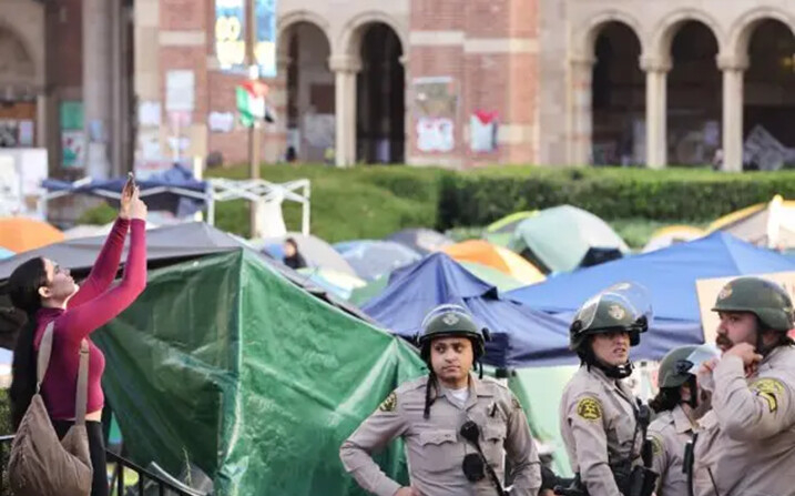 Los agentes del sheriff del condado de Los Ángeles vigilan cerca de un campamento pro-palestino, la mañana después de que fuera atacado por contramanifestantes en el campus de la Universidad de California, en Los Ángeles, el 1 de mayo de 2024. (Mario Tama/Getty Images)

