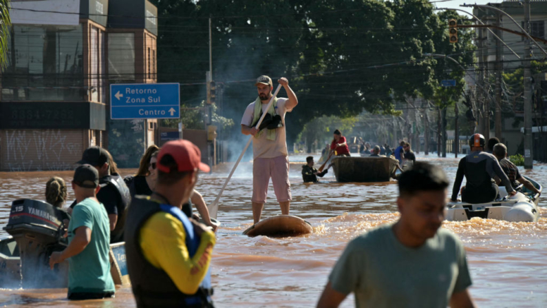 Un hombre avanza en una tabla de SUP tras las inundaciones provocadas por las fuertes lluvias en Porto Alegre, estado de Rio Grande do Sul, Brasil, el 6 de mayo de 2024. (Nelson Almeida/AFP vía Getty Images)