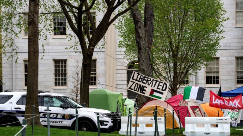 Un coche patrulla de la policía junto a tiendas de campaña y pancartas que llenan Harvard Yard junto a la estatua de John Harvard en el campamento propalestino de la Universidad de Harvard en Cambridge, Massachusetts, el 5 de mayo de 2024. (Joseph Prezioso/AFP vía Getty Images)
