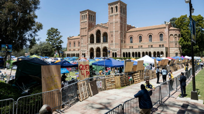 Manifestantes propalestinos reconstruyen la barricada que rodea su campamento tras los enfrentamientos que estallaron durante la noche en el campus de la Universidad de California en Los Ángeles (UCLA), en Los Ángeles, el 1 de mayo de 2024. (Etienne Laurent / AFP vía Getty Images)