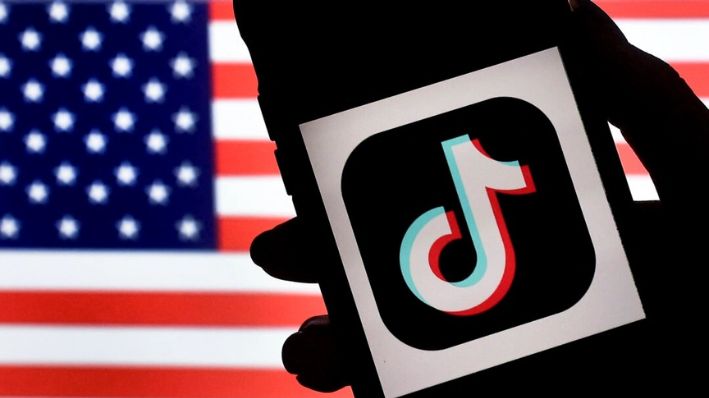 El logotipo de la app de redes sociales TikTok se muestra en la pantalla de un iPhone sobre un fondo de la bandera estadounidense en Arlington, Virginia, el 3 de agosto de 2020. (Olivier Douliery/AFP vía Getty Images)