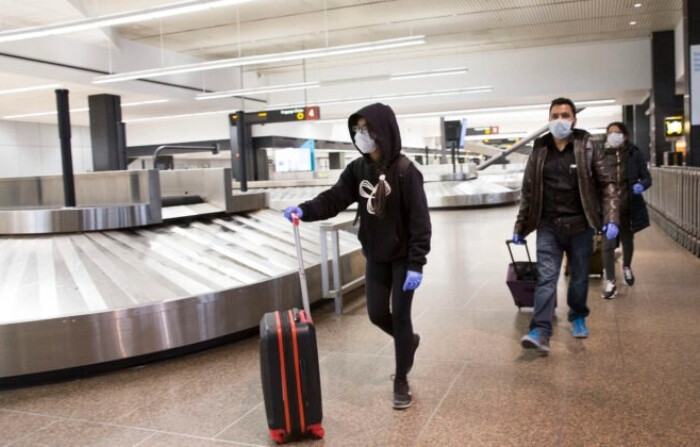 Viajeros recogen sus maletas en el Aeropuerto Internacional Seattle Tacoma (también conocido como Aeropuerto Sea-Tac) el 8 de marzo de 2020 en Seattle, Washington. (Karen Ducey/Getty Images)
