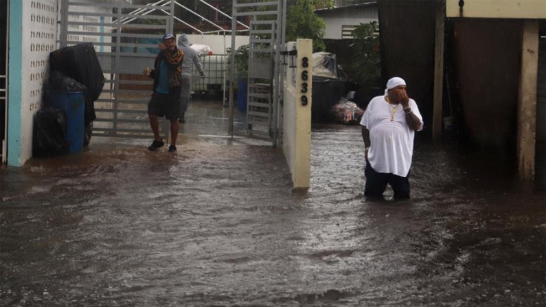 Personas caminan en una calle inundada debido a lluvias en Toa Baja (Puerto Rico). Imagen de archivo. EFE/Thais Llorca