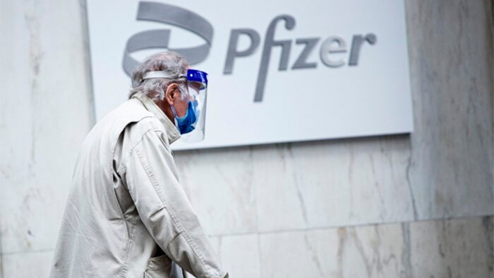 Un hombre con mascarilla y escudo pasa por delante de la sede de Pfizer en Nueva York, el 11 de marzo de 2021. (Kena Betancur/AFP/Getty Images)
