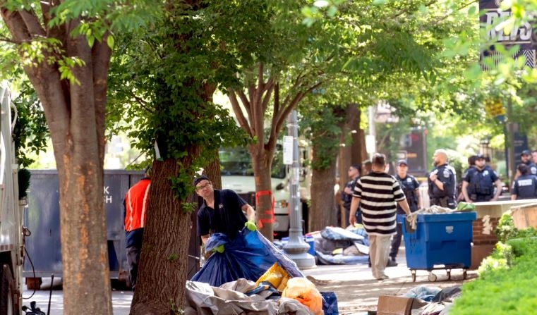 Trabajadores llevan tiendas de campaña de estudiantes a un camión de basura después de que la policía desalojara un campamento pro-Palestina en la Universidad George Washington a primera hora del miércoles y detuviera a los manifestantes en Washington el 8 de mayo de 2024. (Jose Luis Magana/AP Photo)