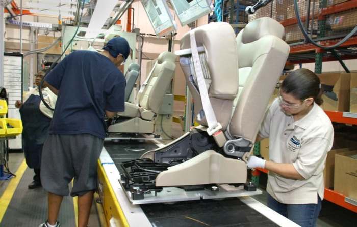Los trabajadores de producción ensamblan asientos para automóviles en la planta de fabricación de Bridgewater Interiors en Warren, Michigan, el 8 de marzo de 2004. (Bill Pugliano/Getty Images)