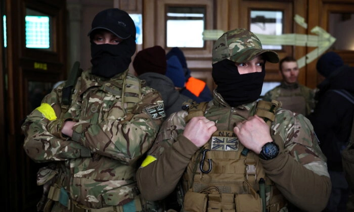 Dos combatientes extranjeros del Reino Unido listos para partir hacia la línea del frente en Lyiv, Ucrania, el 5 de marzo de 2022. (Kal Pfaffenbach/Reuters)
