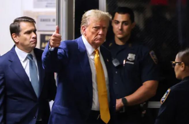 El expresidente Donald Trump da un pulgar hacia arriba mientras regresa a la sala después de un descanso en su juicio por presuntamente encubrir pagos de dinero por silencio en el Tribunal Penal de Manhattan el 2 de mayo de 2024. (Charly Triballeau/Getty Images)