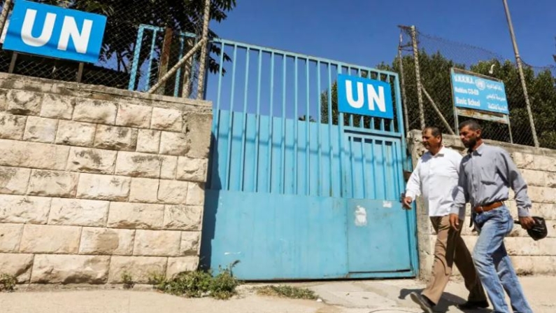 Palestinos pasan por la puerta de una escuela administrada por UNRWA en Nablus en Cisjordania, 13 de agosto de 2018. (Abed Omar Qusini/Reuters)