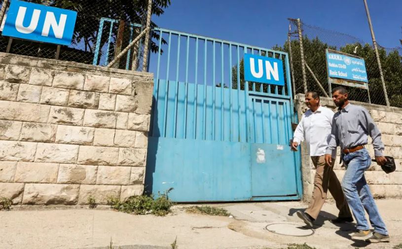 Palestinos pasan por la puerta de una escuela administrada por UNRWA en Nablus en Cisjordania, 13 de agosto de 2018. (Abed Omar Qusini/Reuters)