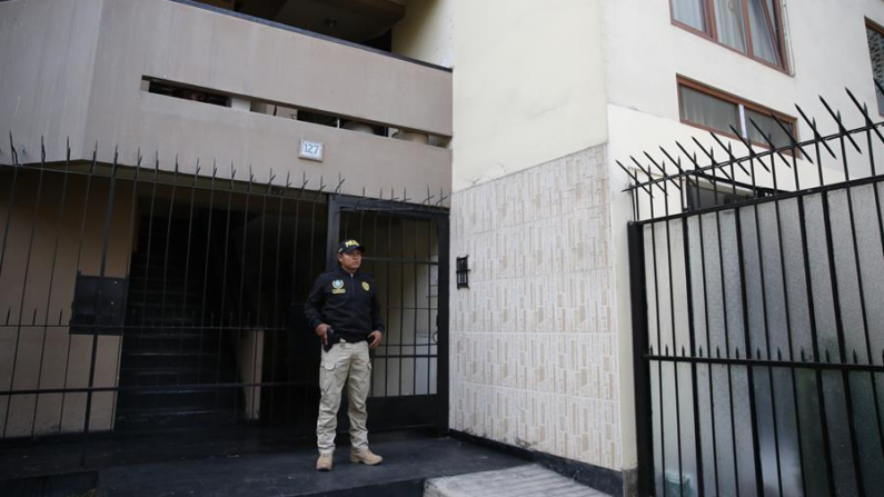 Fotografía que muestra un policía mientras resguarda el ingreso de la vivienda de Nicanor Boluarte, hermano de la presidenta de Perú Dina Boluarte, durante el allanamiento que se esta ejecutando por parte de la Fiscalía este viernes en Lima (Perú). EFE/Paolo Aguilar