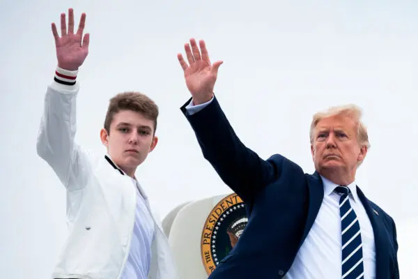 El presidente Donald Trump (D) y su hijo Barron saludan mientras abordan el Air Force One en el Aeropuerto Municipal de Morristown en Morristown, Nueva Jersey, el 16 de agosto de 2020. (Jim Watson/AFP vía Getty Images)