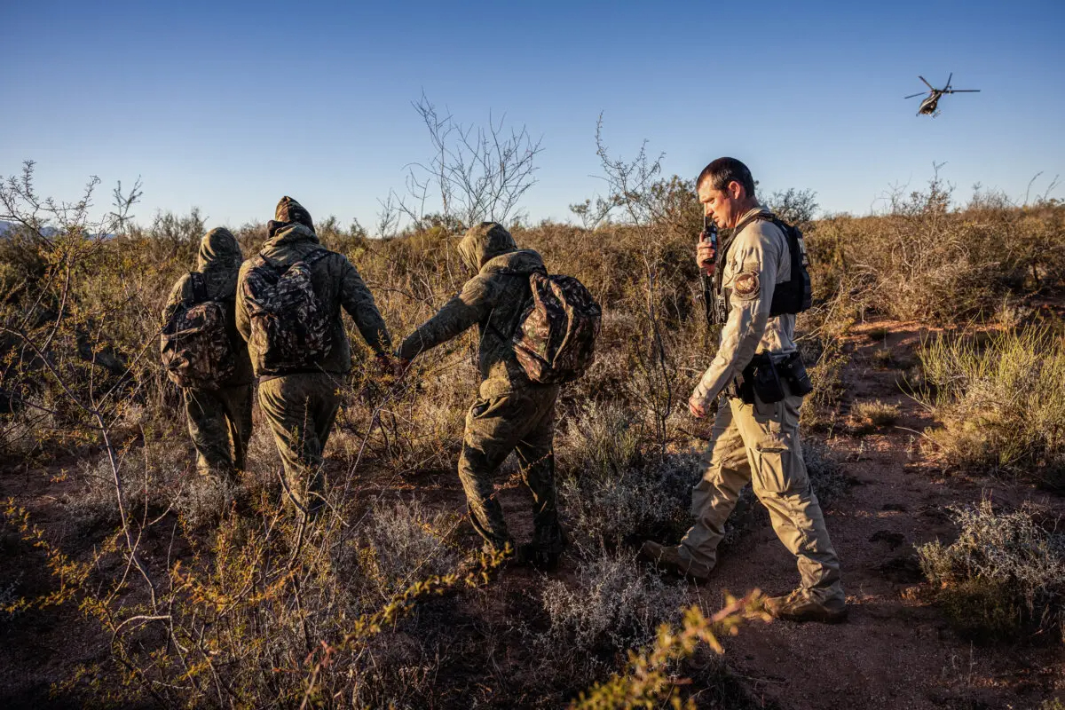 Un agente fronterizo detiene a ciudadanos mexicanos camuflados que entraron ilegalmente en Estados Unidos cerca de Naco, Arizona, el 4 de noviembre de 2022. (John Moore/Getty Images)