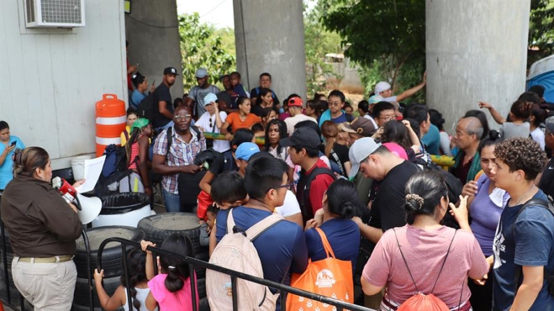 Migrantes permanecen en un punto de revisión del Instituto Nacional de Migración (INM) para entregarse y ser trasladados a Tuxtla Gutiérrez este lunes 13 de mayo de 2024, en Chiapas (México). EFE/ Juan Manuel Blanco