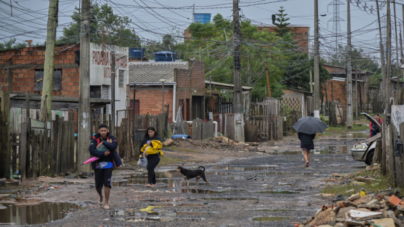 Residentes sacan sus pertenencias de sus casas inundadas en el barrio Harmonia de la ciudad de Canoas, estado de Rio Grande do Sul, Brasil, el 13 de mayo de 2024. (Nelson Almeida/AFP vía Getty Images)