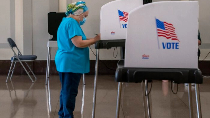 Un votante deposita su boleta en un centro de votación en el Baltimore War Memorial Building durante las elecciones primarias de mitad de mandato en Baltimore, Maryland, el 19 de julio de 2022. (Nathan Howard/Getty Images)