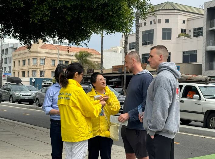 La gente se detiene para preguntar sobre la 25ª celebración del Día de Falun Dafa en Santa Mónica, California, el 12 de mayo de 2024. (Linda Jiang/The Epoch Times)