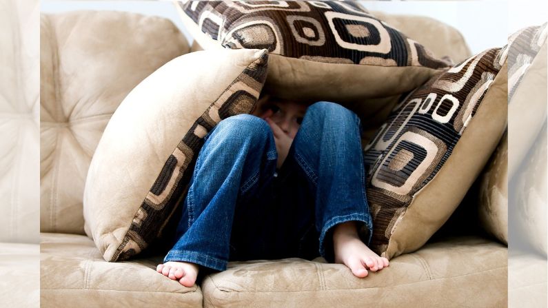 Un niño escondiéndose en un sofá. Imagen de archivo. (Ambermb/Pixabay)