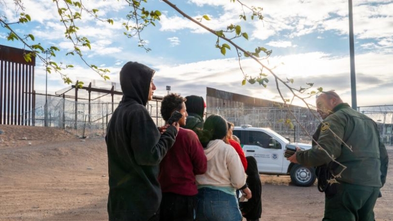 Un grupo de migrantes espera a ser procesado después de cruzar el río Grande en El Paso, Texas, el 2 de abril de 2024. (Brandon Bell/Getty Images)