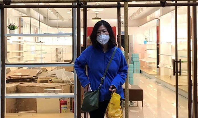 Zhang Zhan permanece cerca de unos andamios en el exterior de una tienda durante una visita a Wuhan, en la provincia china de Hubei, el 11 de abril de 2020. (Cortesía de Melanie Wang vía AP)