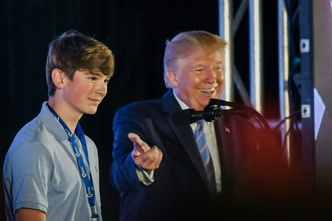 El presidente Donald Trump junto a un estudiante en el escenario durante un evento de Turning Point USA en Washington el 23 de julio de 2019. (Nicholas Kamm/AFP vía Getty Images)