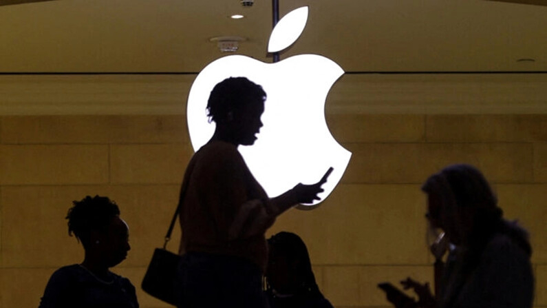 Una mujer utiliza un iPhone al pasar por la tienda de Apple en la Grand Central Terminal de Nueva York, el 14 de abril de 2023. (Mike Segar/Reuters)
