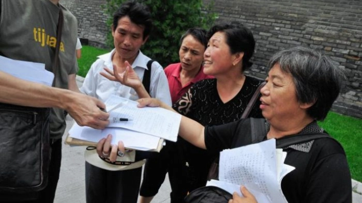 Peticionarios chinos muestran sus documentos con sus quejas a un periodista cerca de una oficina de peticiones en Beijing el 2 de julio de 2008. (Teh Eng Koon/AFP/Getty Images)