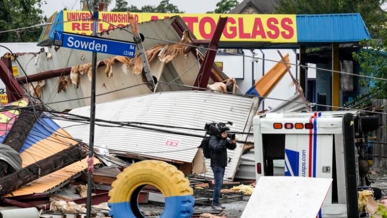Un periodista filma los daños en una tienda de neumáticos tras una fuerte tormenta en Houston, Texas, el 17 de mayo de 2024. (Brett Coomer/Houston Chronicle vía AP)