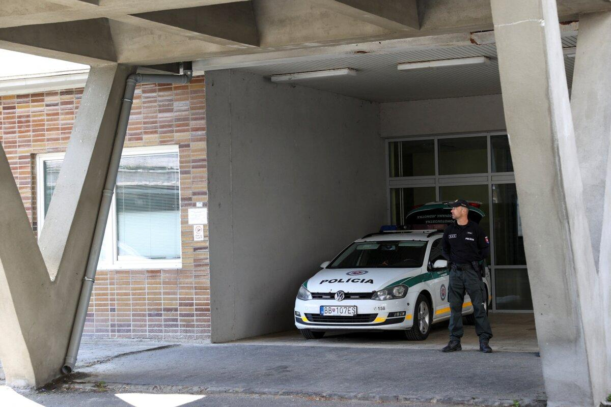 Un agente de policía junto a un vehículo policial aparcado frente al Hospital Universitario F.D. Roosevelt, donde está siendo tratado el primer ministro eslovaco Robert Fico, en Handlova, Banska Bystrica, Eslovaquia, el 18 de mayo de 2024. (Bernadett Szabo/Reuters)