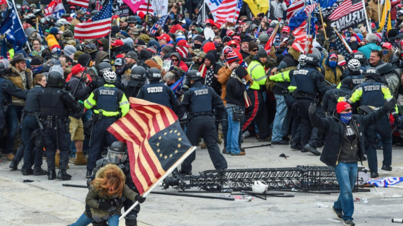 La policía intenta contener a los manifestantes en la Plaza Oeste del Capitolio de los Estados Unidos el 6 de enero de 2021. (Roberto Schmidt/AFP via Getty Images)