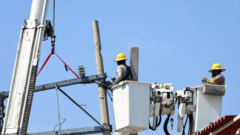 Trabajadores de la Comisión Federal de Electricidad reparan el suministro de energía eléctrica tras la destrucción causada por el huracán Otis en Acapulco, estado de Guerrero, México, el 6 de noviembre de 2023. (Francisco Robles/AFP vía Getty Images)