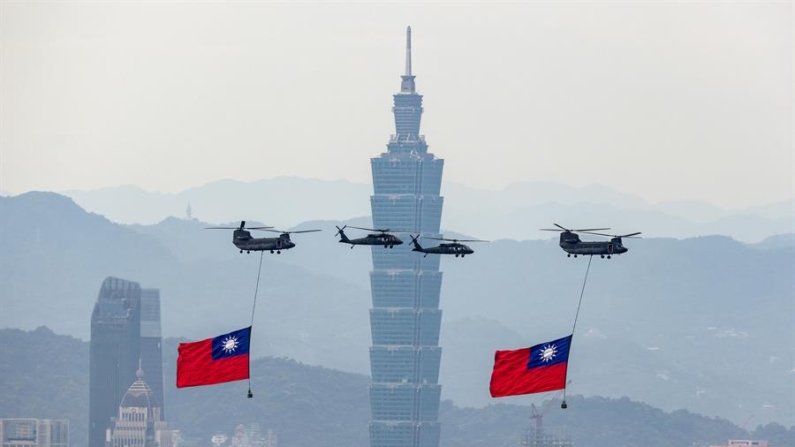 Helicópteros de la Fuerza Aérea de Taiwán llevan banderas nacionales mientras realizan un sobrevuelo durante un ensayo antes de la toma de posesión del presidente electo William Lai en Taipei, Taiwán. EFE/EPA/Ritchie B. Tongo
