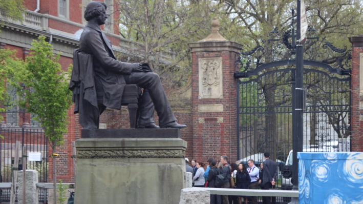 Un grupo de turistas de la Universidad de Harvard ante las puertas cerradas de la universidad el 29 de abril de 2024. (Alice Giordano/Epoch Times)