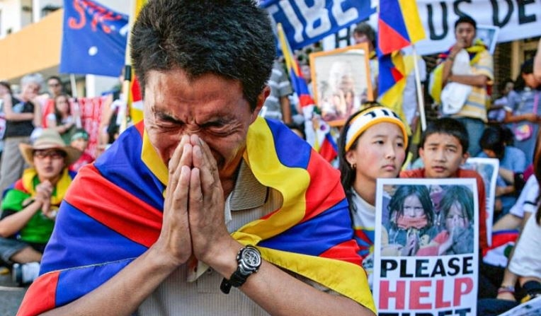 Manifestantes pro-tibetanos rezan por los derechos humanos en el Tíbet durante una protesta ante el consulado chino en Sidney, Australia, el 18 de marzo de 2008. (Anoek De Groot/AFP vía Getty Images)
