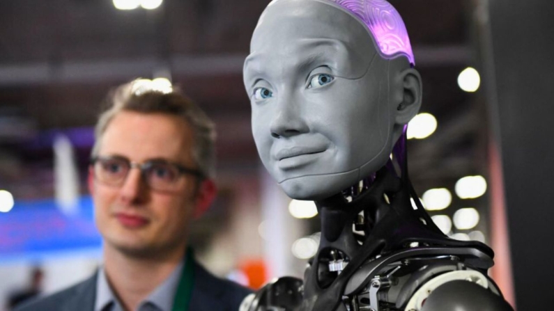 Morgan Roe, director de operaciones de Engineered Arts, habla sobre el robot humanoide Engineered Arts Ameca con inteligencia artificial durante el Consumer Electronics Show (CES) el 5 de enero de 2022 en Las Vegas, Nevada. (Patrick T. FALLON/AFP vía Getty Images)