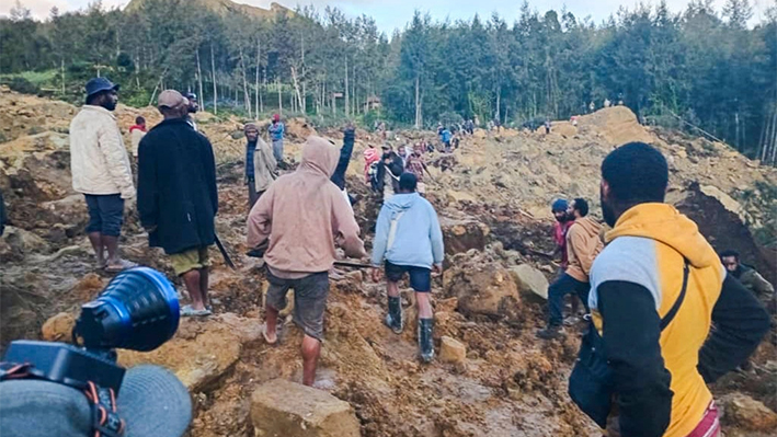 Varias personas se reúnen en el lugar donde se produjo un corrimiento de tierras en Maip Mulitaka, en la provincia de Enga, en Papúa Nueva Guinea, el 24 de mayo de 2024. Funcionarios locales y grupos de ayuda dijeron que un deslizamiento de tierra masivo golpeó una aldea en las tierras altas de Papúa Nueva Guinea el 24 de mayo, y se teme que muchas personas hayan muerto. (STR/AFP vía Getty Images)