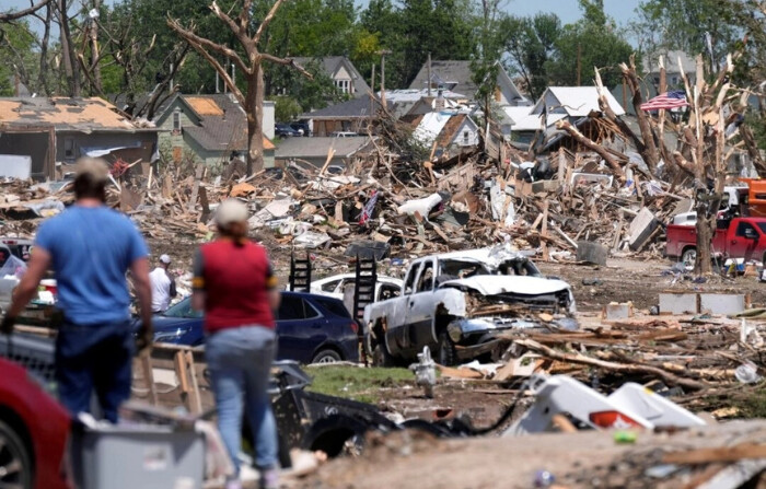 Un grupo de personas inspecciona un barrio dañado por un tornado en Greenfield, Iowa, el 23 de mayo de 2024. (Charlie Neibergall/Foto AP)