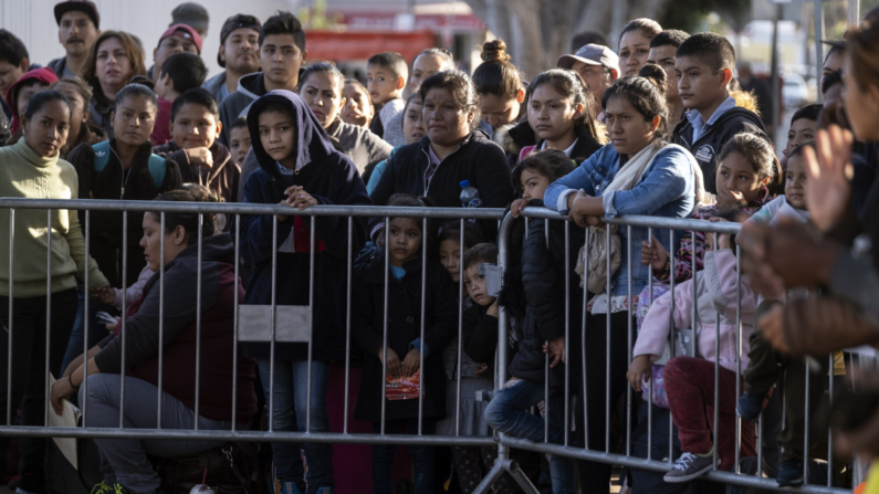 Solicitantes de asilo se reúnen mientras buscan una fecha de cita con las autoridades estadounidenses fuera del puerto de cruce El Chaparral en la frontera entre Estados Unidos y México en Tijuana, estado de Baja California, México, el 18 de octubre de 2019. (GUILLERMO ARIAS/AFP vía Getty Images)