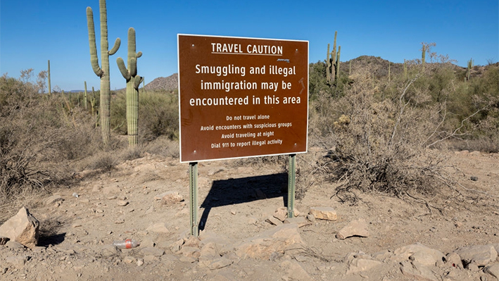 Una señal de advertencia sobre el contrabando y la inmigración ilegal se encuentra en el Monumento Nacional Organ Pipe Cactus cerca de la frontera entre EE. UU. y México en Lukeville, Arizona, el 08 de diciembre 2023. (John Moore/Getty Images)