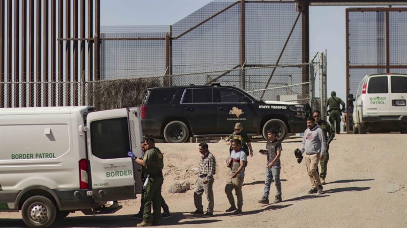 Migrantes detenidos son llevados por miembros de la Patrulla Fronteriza estadounidense a un vehículo, junto al muro fronterizo en El Paso, Texas (EE.UU.). Fotografía de archivo. EFE/ Jonathan Fernández