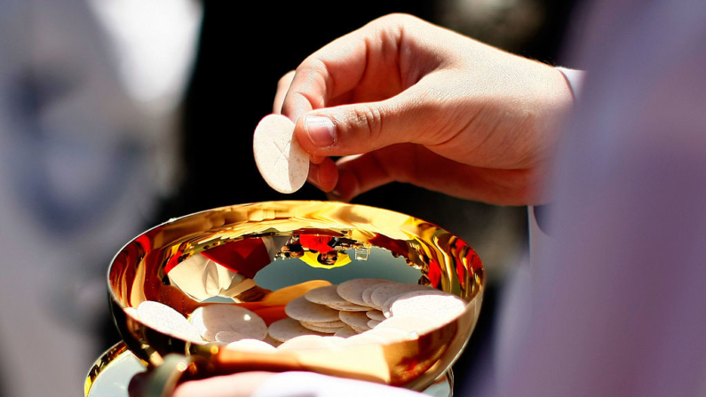 Un sacerdote sostiene una hostia de la Sagrada Comunión en una fotografía de archivo. (Win McNamee/Getty Images)