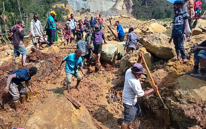 Aldeanos buscan entre un corrimiento de tierras en Yambali, en las tierras altas de Papúa Nueva Guinea, el 26 de mayo de 2024. (Mohamud Omer/Organización Internacional para las Migraciones vía AP)
