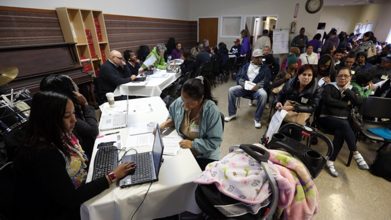 Trabajadores ayudan a los solicitantes a inscribirse en un seguro de salud durante una feria de inscripción en la Misión de Rescate del Área de la Bahía en Richmond, California, el 31 de marzo de 2014. (Justin Sullivan/Getty Images)
