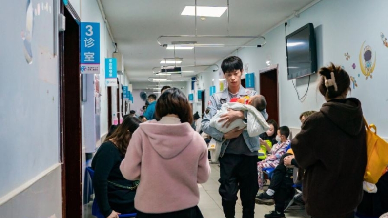 Unos padres con niños que sufren de enfermedades respiratorias esperan en un hospital infantil en Chongqing, China, el 23 de noviembre de 2023. (CFOTO/Future Publishing vía Getty Images)
