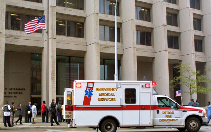 Una bandera estadounidense ondea a media asta y una ambulancia se encuentra frente al Edificio Federal McNamara, en Detroit, el 21 de septiembre de 2001. (Bill Pugliano/Getty Images)